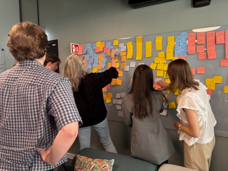 Studenter som monterer postit-lapper. Foto. 